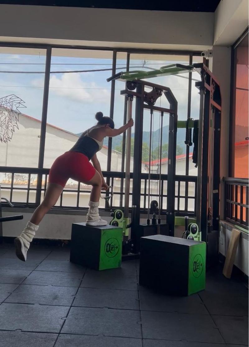 Persona entrenando en máquina de poleas en NB Fitness